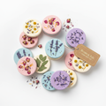 Flat round vegan bath bomb discs with pressed dried flowers and botanicals